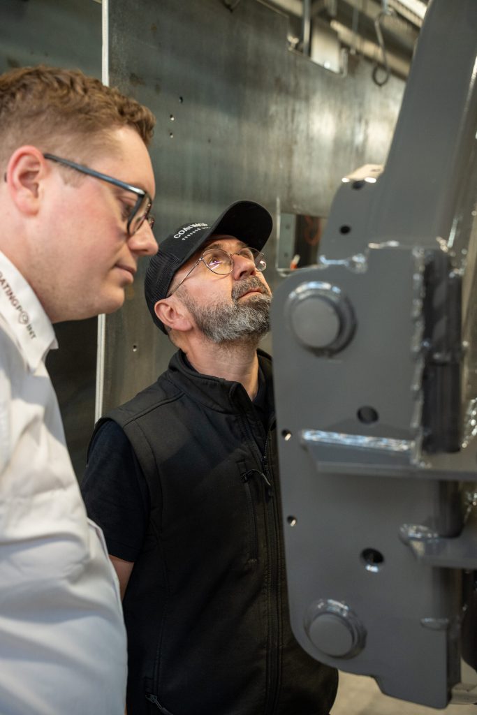 Employees inspecting a coated component